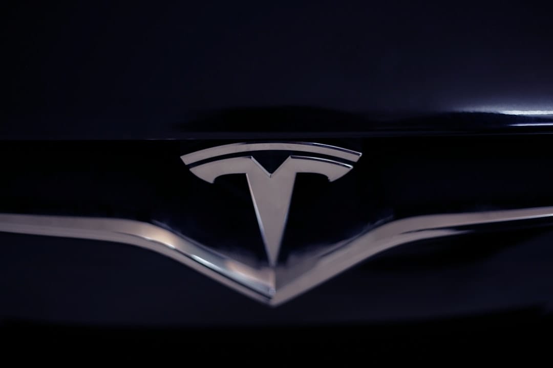 Nærbillede af Tesla-logo på en mørk bilgrill