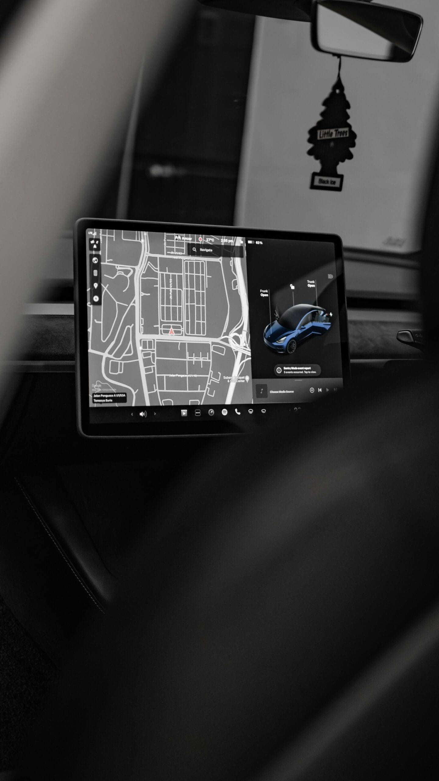 Tesla bil interiør med close-up af touch screen, der viser navigation og bilindstillinger