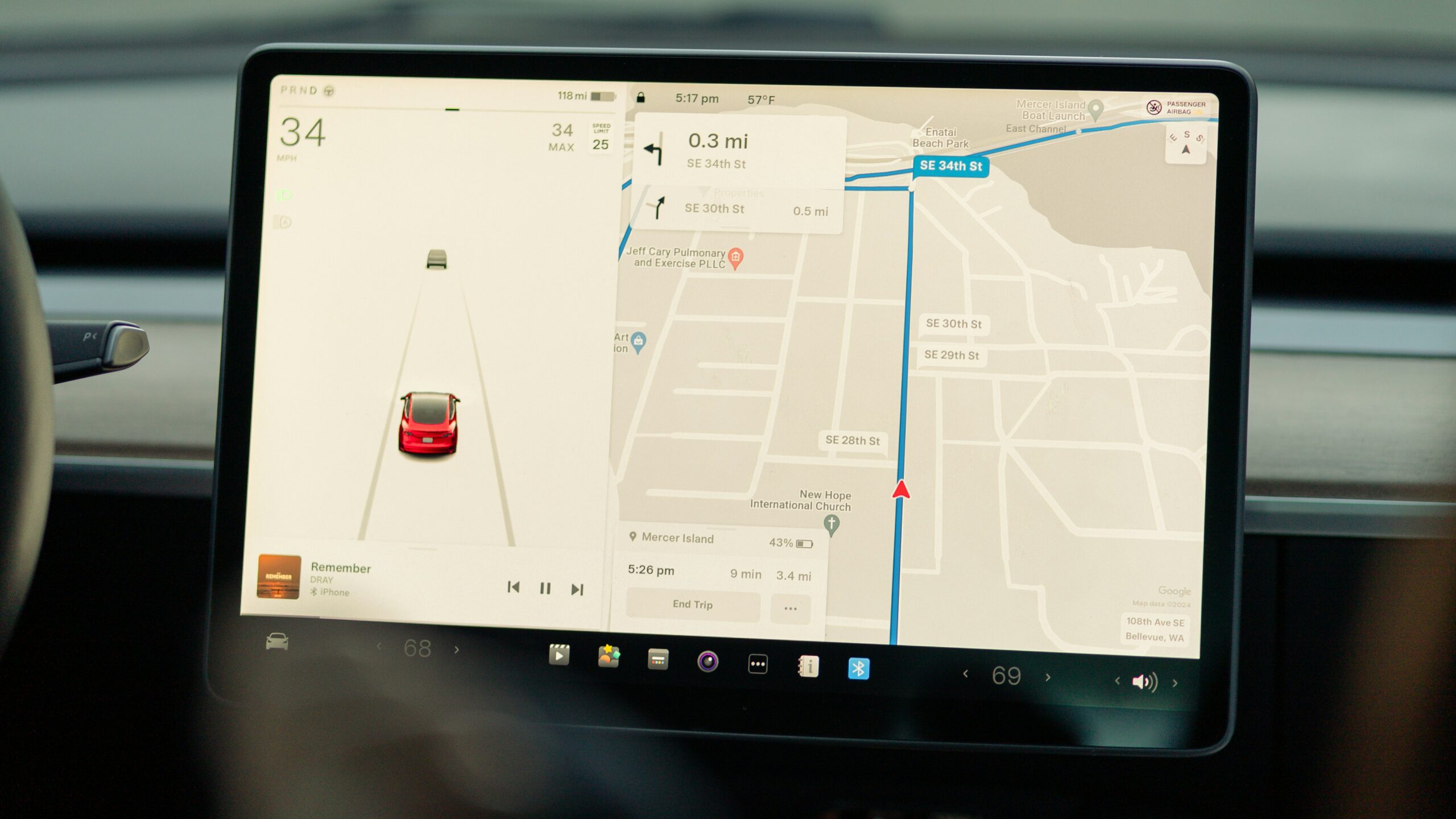 Tesla bilens indbyggede touchscreen vises med et navigationskort og vejledning, musikafspiller samt bilen omgivelser der ses på skærmen.