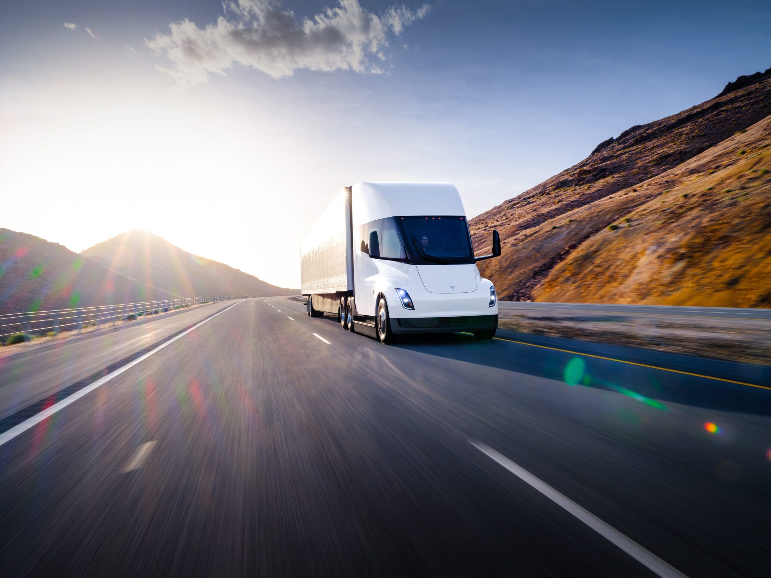 Tesla semi-lastbil kører på en motorvej ved solnedgang