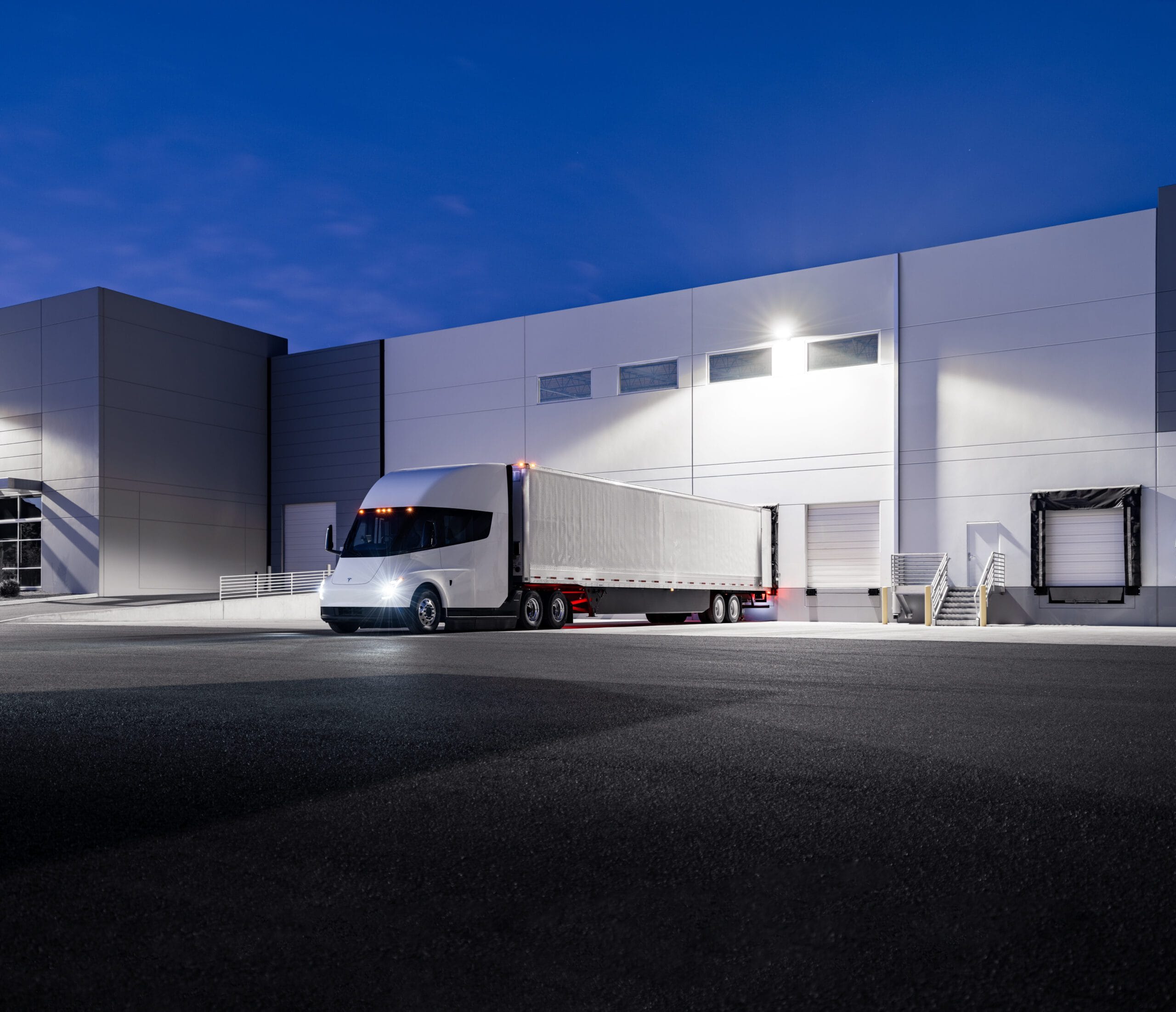 Tesla Semi-truck parkeret foran en industriel bygning ved skumringen