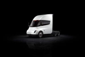 Futuristisk hvid Tesla-lastbil står i spotlight på mørkt baggrund