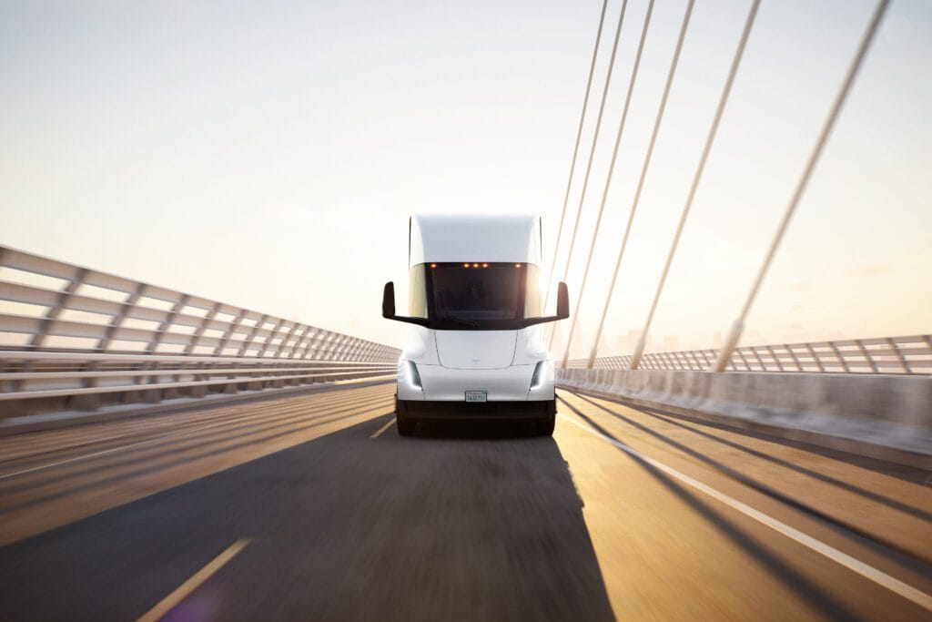 Tesla elektrisk lastbil kører på en moderne bro i solskin