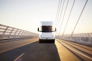 Tesla elektrisk lastbil kører på en moderne bro i solskin