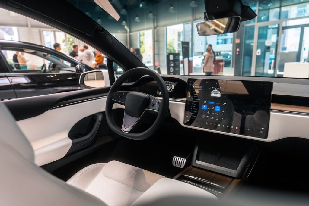 Tesla Model 3 interiør med moderne touchscreen display og førsteklasses design i en udstillingshal