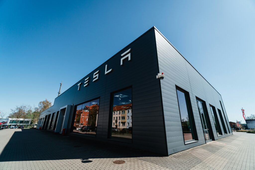 En moderne Tesla-bygning med solrig blå himmel i baggrunden