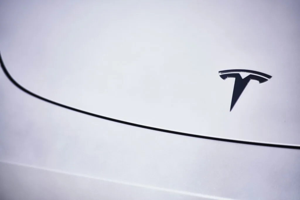 Tesla logo på en hvid bil, symboliserer den futuristiske teknologi og design af elbiler