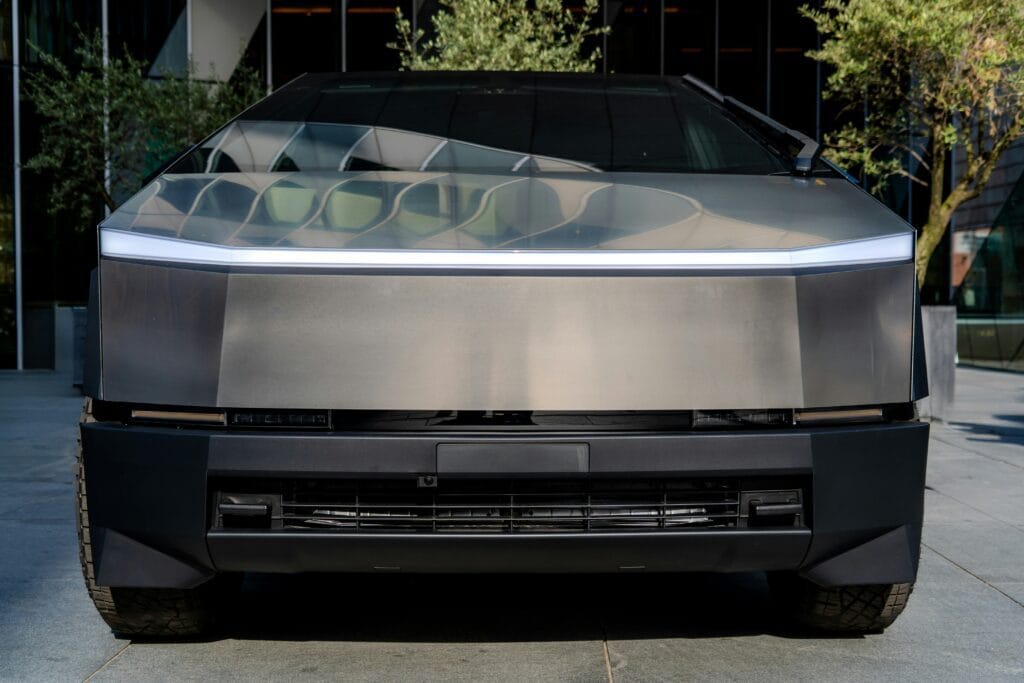 Futuristisk Tesla Cybertruck parkeret foran en moderne bygning