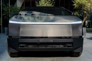Futuristisk Tesla Cybertruck parkeret foran en moderne bygning