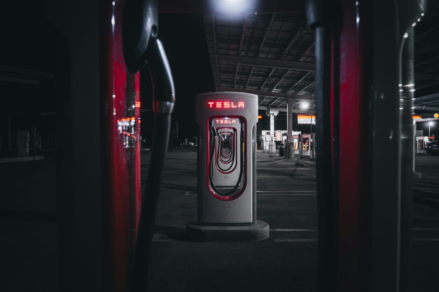 Tesla Supercharger-station om natten med moderne design og oplyst logo, der fremhæver bæredygtig teknologi.