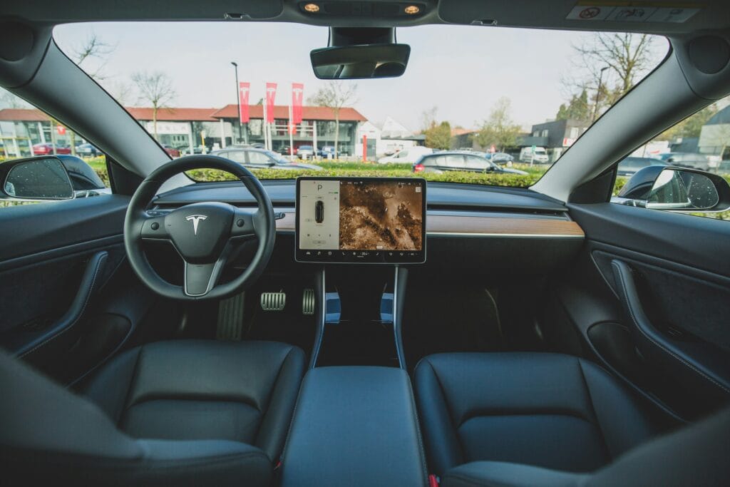 Tesla bil interiør med moderne displayskærm og stilfuldt design