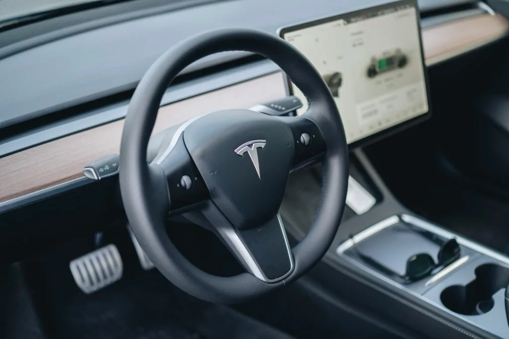 Tesla Model 3 interiør med fokus på rattet og skærmens brugerinterface