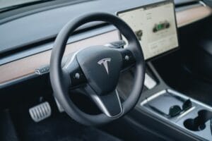 Tesla Model 3 interiør med fokus på rattet og skærmens brugerinterface