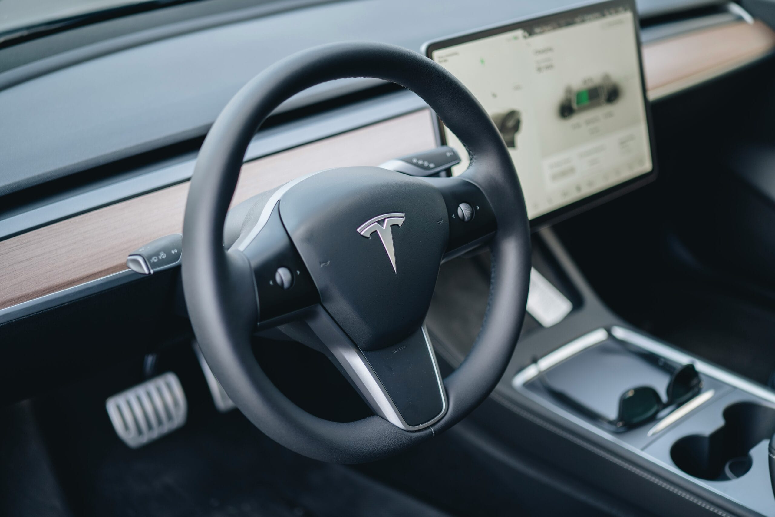 Tesla Model 3 interiør med fokus på rattet og skærmens brugerinterface