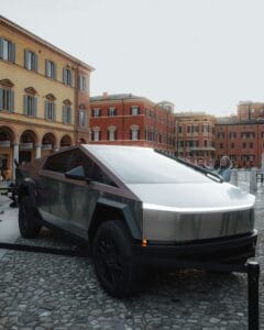 Tesla Cybertruck parkeret på brostensbelagt plads foran farverige europæiske bygninger.