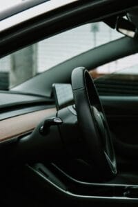 Tesla bilinteriør med rattet og minimalistisk design i fokus.