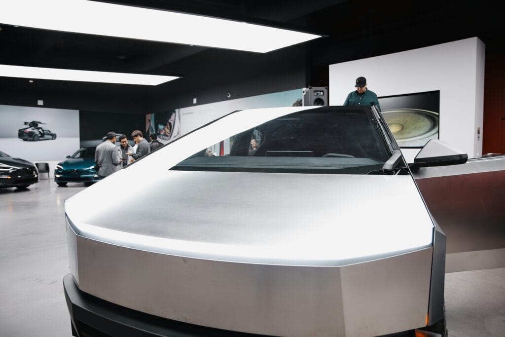 Tesla Cybertruck i udstillingslokale med folk der diskuterer