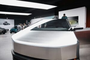 Tesla Cybertruck i udstillingslokale med folk der diskuterer