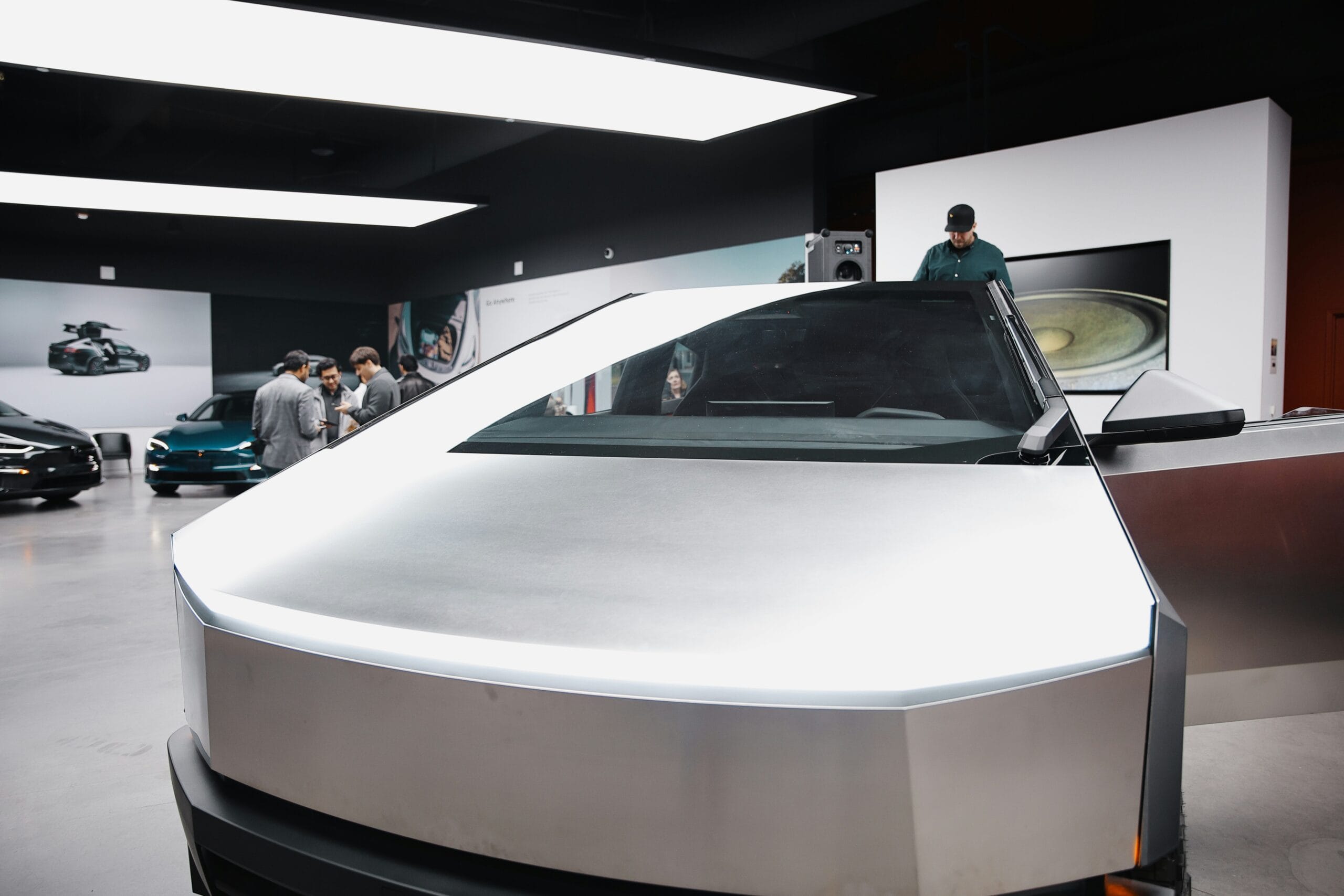 Tesla Cybertruck i udstillingslokale med folk der diskuterer