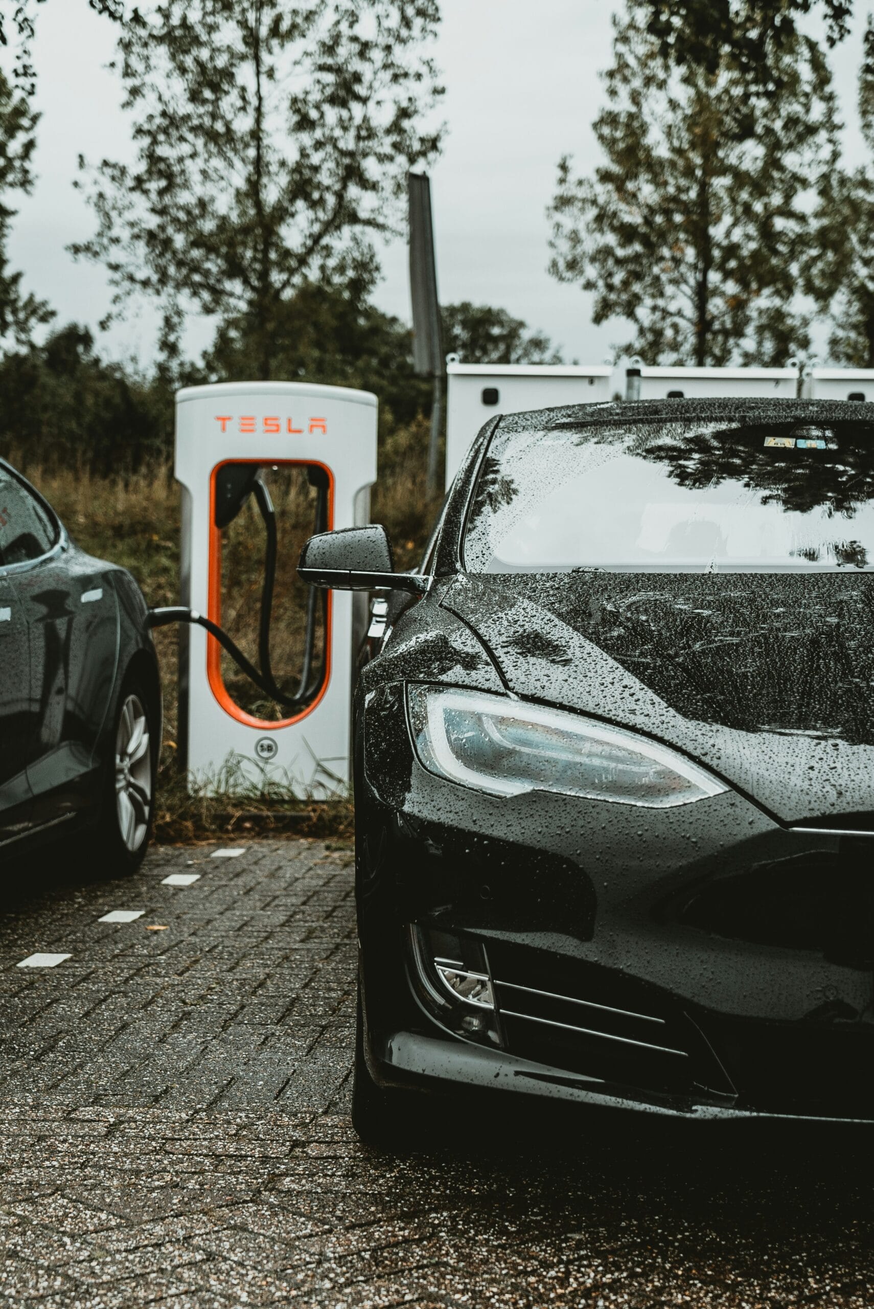 Sort Tesla ved ladestation en regnfuld dag