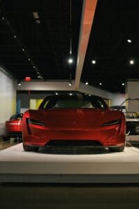 Fremvisning af en rød Tesla sportsbil på et museumsudstilling