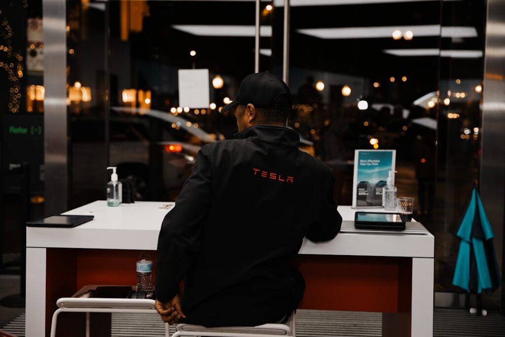 Person i Tesla-jakke ved et bord i moderne butiksmiljø