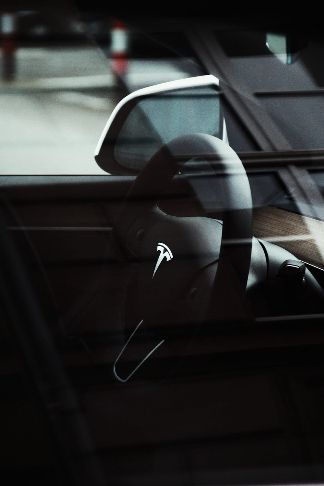 Tesla bil interiør med rat og sidespejl.