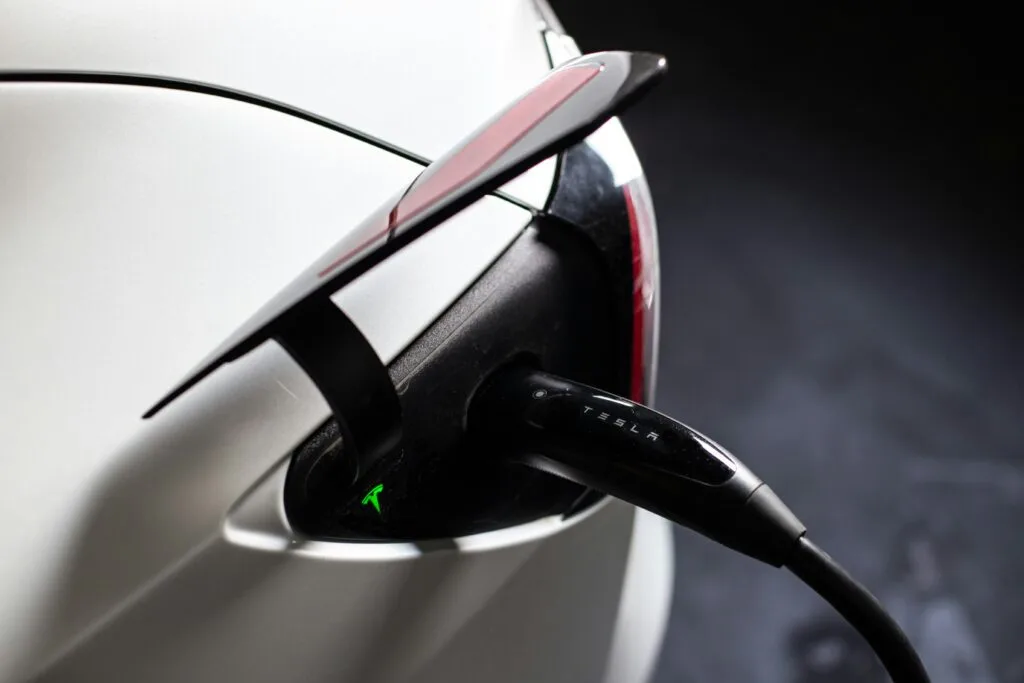 Tesla elbil bliver opladet med ladekabel i ladestik.
