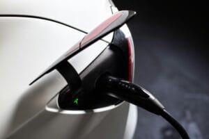 Tesla elbil bliver opladet med ladekabel i ladestik.