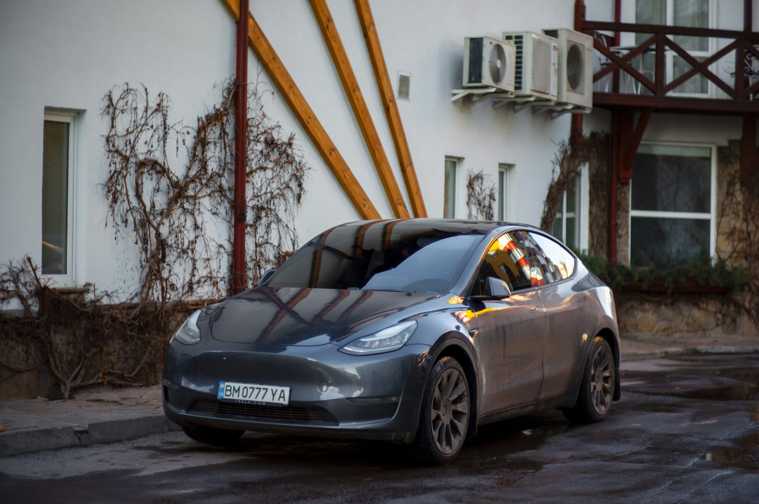 Tesla Model Y parkeret foran en bygning med klatreplanter på væggen
