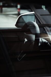 Tesla rat vises gennem bilruden med logoet tydeligt i midten.