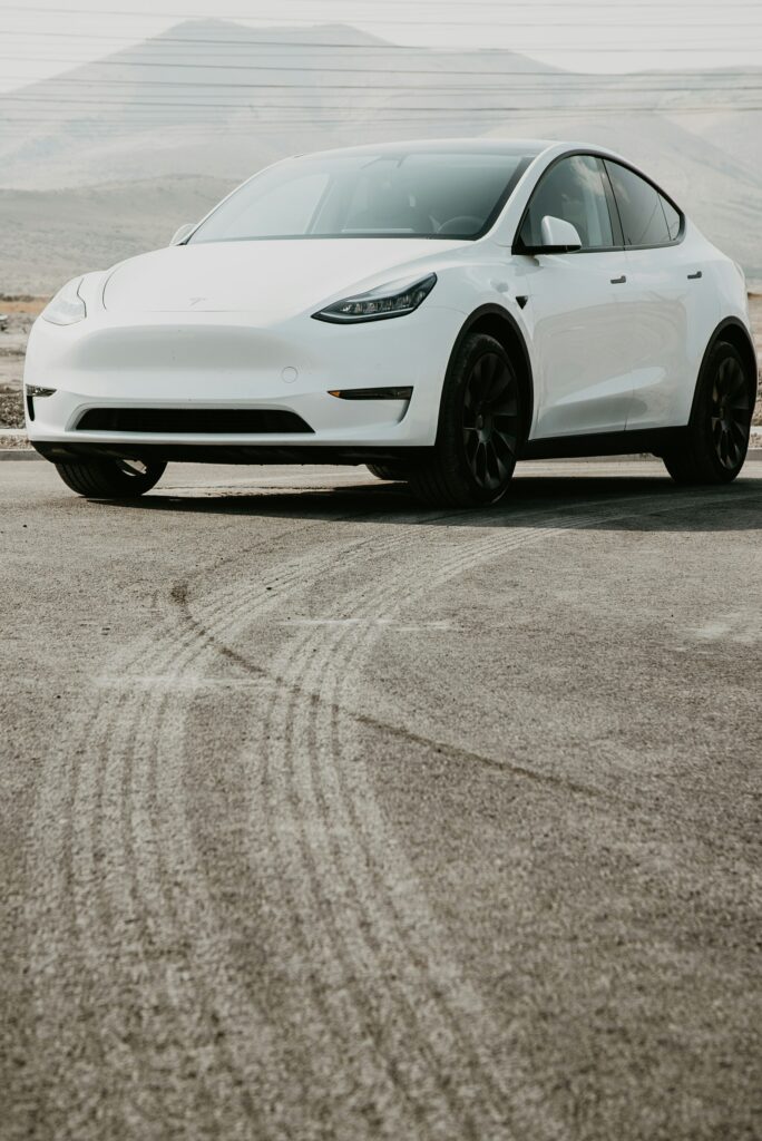Tesla Model Y kører på en åben vej med bjerge i baggrunden
