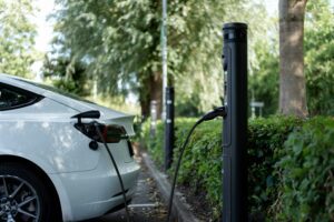 Tesla-bil oplades ved ladestation i grønne omgivelser
