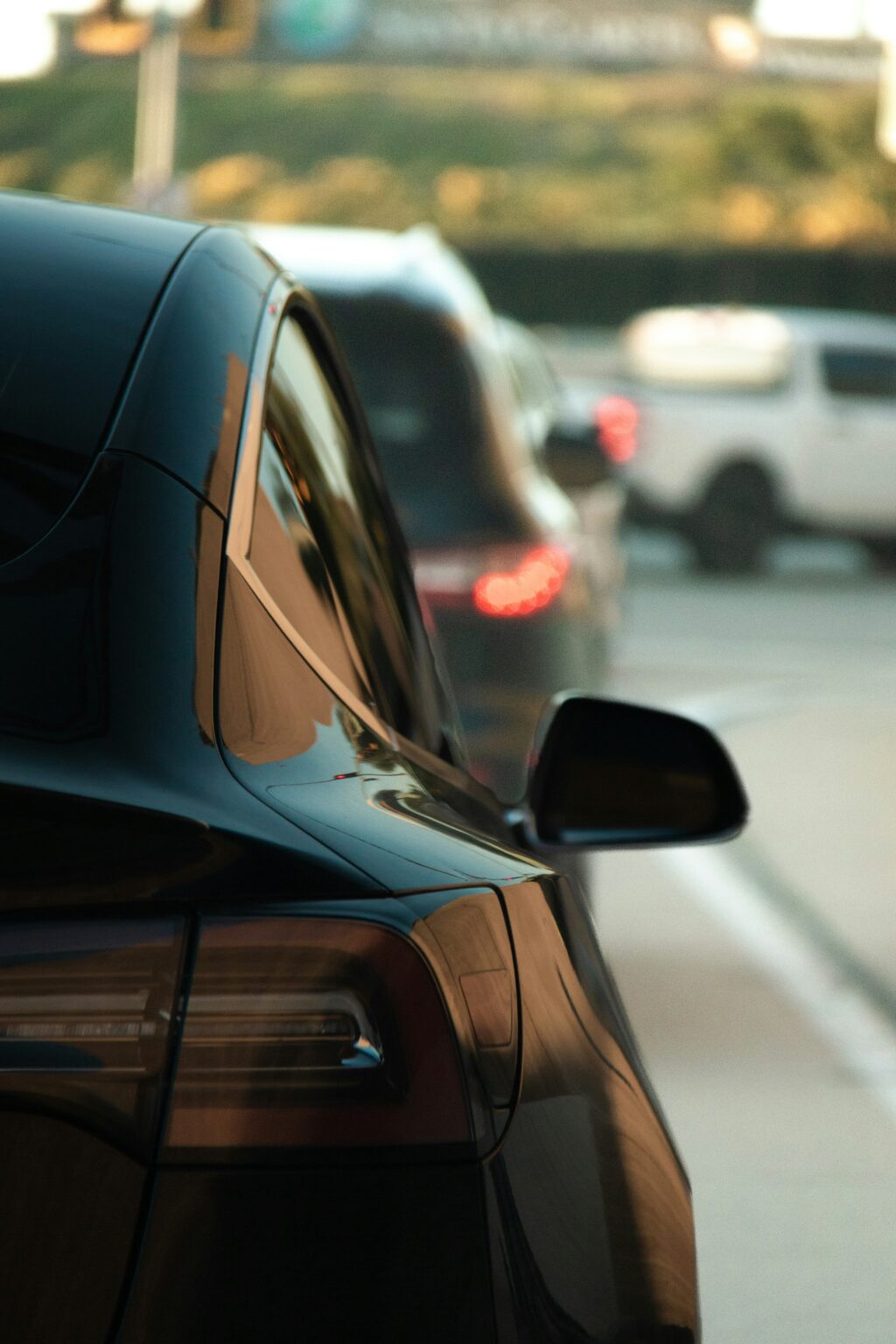 Tesla Model X bagfra i bytrafik med solnedgangsrefleksioner