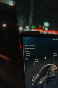 Tesla bilskærm viser opladningsstatus med 45 minutters resterende tid og 100% opladningsgrænse