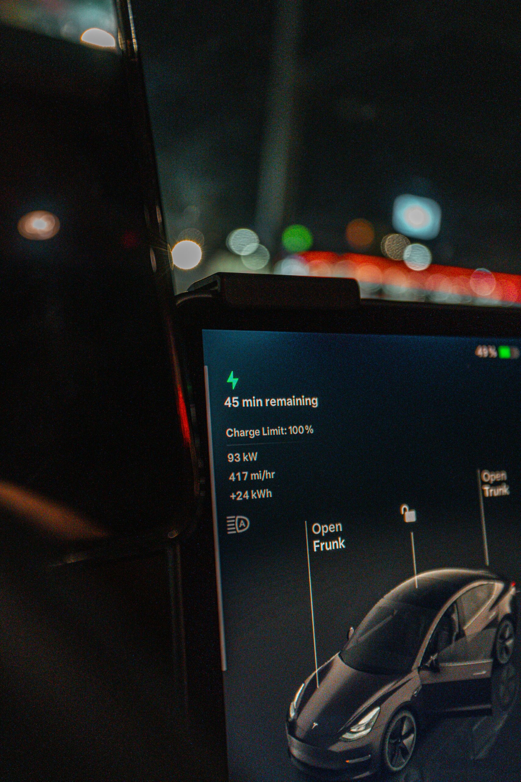 Tesla bilskærm viser opladningsstatus med 45 minutters resterende tid og 100% opladningsgrænse