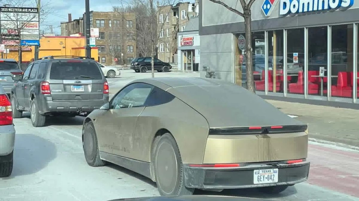 Prototype af elektrisk bil observeret på gaden med en futuristisk, glat design.