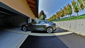 Tesla bil oplader i garage med udsigt over landskab.