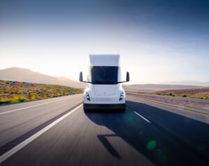 Tesla lastbil på en øde motorvej med bjerglandskab i baggrunden