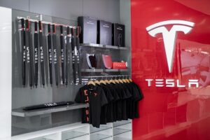 Tesla merchandise i en butik, inklusive paraplyer, poloshirts og wall connectors