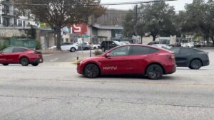 Tesla biler i bymiljø parkeret ved gaden med moderne bygninger i baggrunden