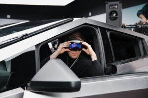 Person sidder i en futuristisk Tesla-bil med high-tech briller, klar til en innovativ oplevelse.
