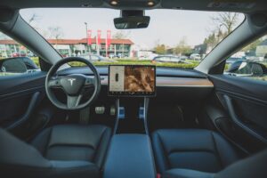 Indvendigt overblik over Tesla Model 3 med digital skærm og moderne design