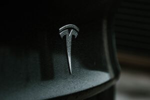 Tesla logo på en våd sort overflade