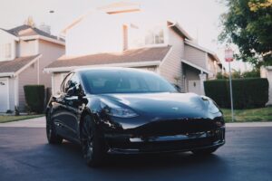 Sort Tesla elbil parkeret foran et hus