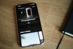 Tesla mobilapp vises på en smartphone-skærm med opladningsnetværk funktion