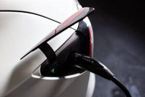 Tesla bil ved opladningsstation med tilsluttet ladekabel
