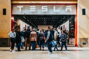 Folk samles foran en Tesla-butik i et indkøbscenter