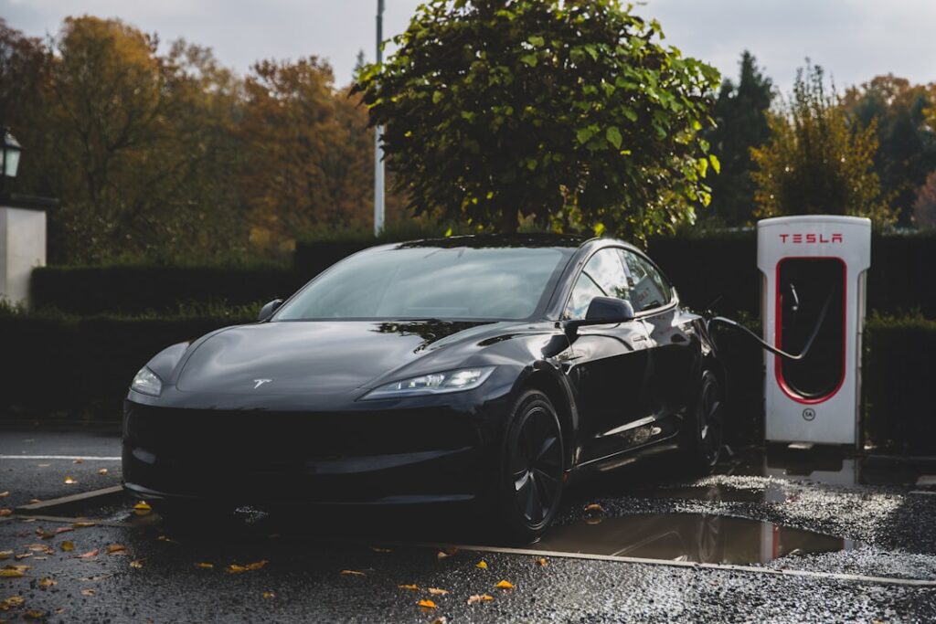 Sort Tesla-bil ved ladestation om efteråret