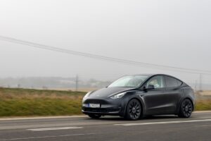 Tesla-model kører på landevej i tåget vejr